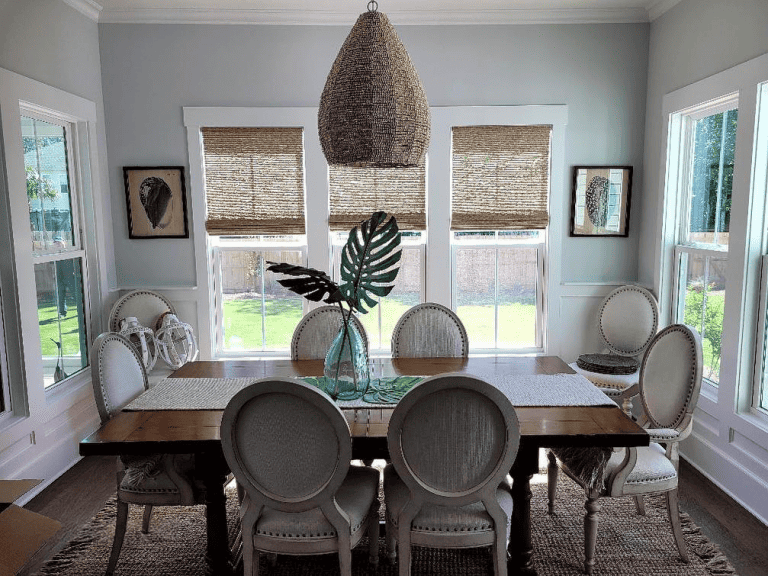 natural woven roman shades installed in a dining room.