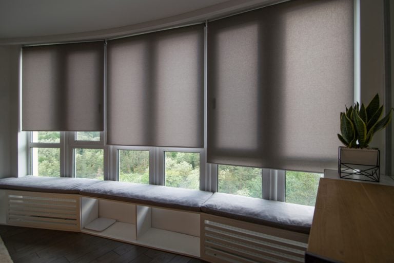 Beige motorized roller shades in a stylish interior, offering automatic control for comfort and convenience, installed in a home in Pender County, NC by Coastal Window Fashions