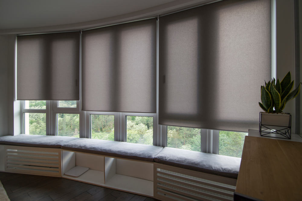 Beige motorized roller shades in a stylish interior, offering automatic control for comfort and convenience, installed in a home in Pender County, NC by Coastal Window Fashions