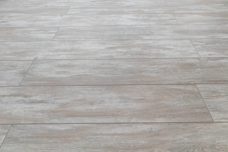 Light gray wood-look floor tiles in a staggered pattern complement window treatments in North Carolina.