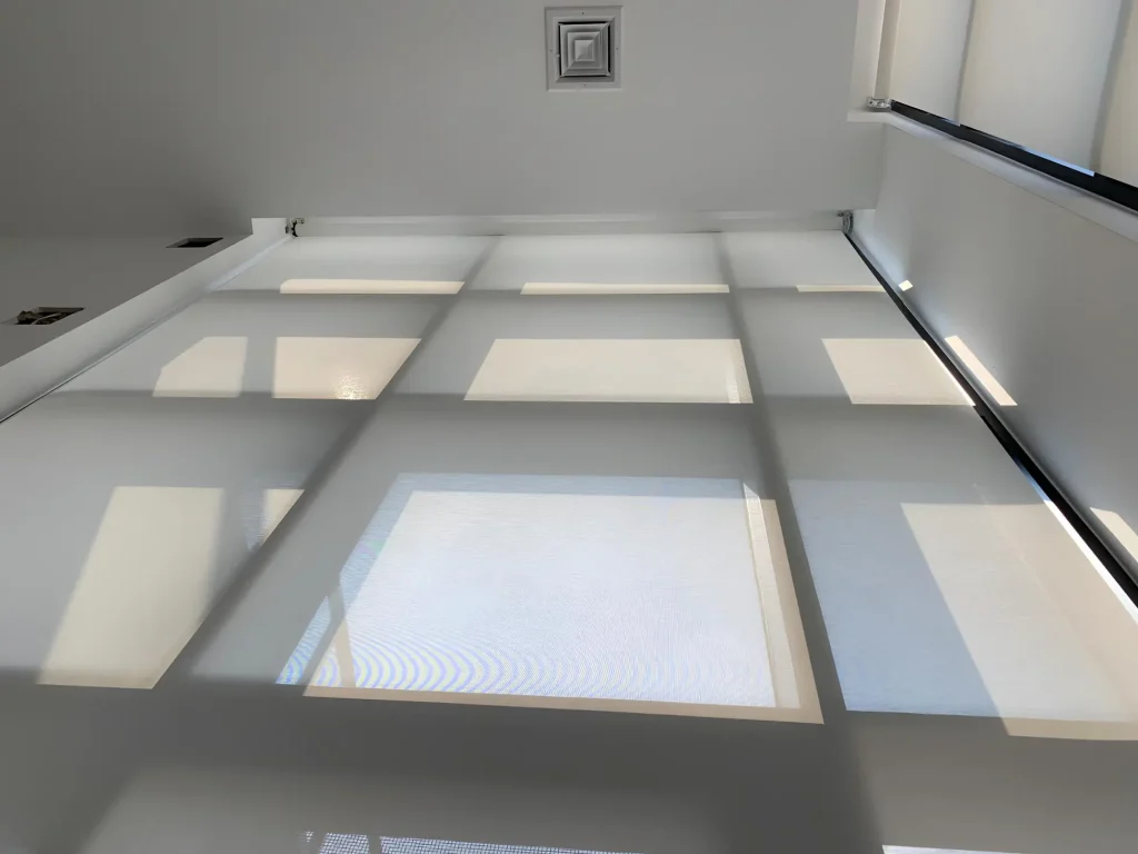 Sunlight streams through frosted panels, casting geometric shadows—Window Treatments North Carolina style.